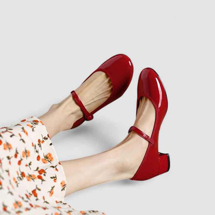 A woman wearing glossy black Mary Jane shoes with a low block heel, comfortable and steady during a day of errands.