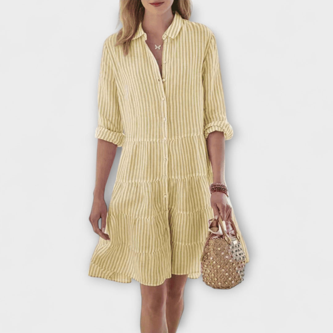 Woman wearing the Renee™ striped button-through shirt dress with roll-up sleeves, walking outdoors in the sunshine.