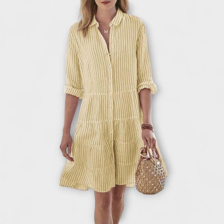 Woman wearing the Renee™ striped button-through shirt dress with roll-up sleeves, walking outdoors in the sunshine.