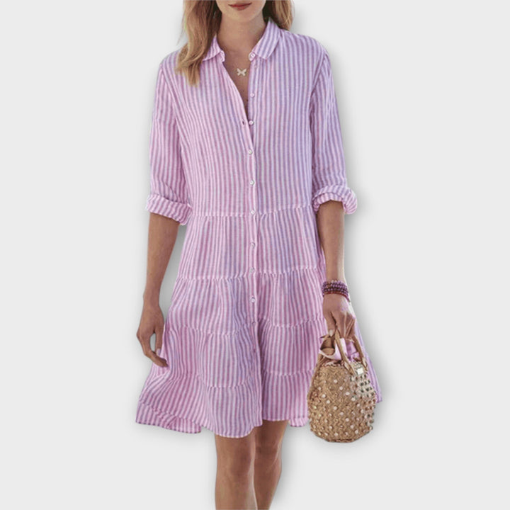 Woman wearing the Renee™ striped button-through shirt dress with roll-up sleeves, walking outdoors in the sunshine.