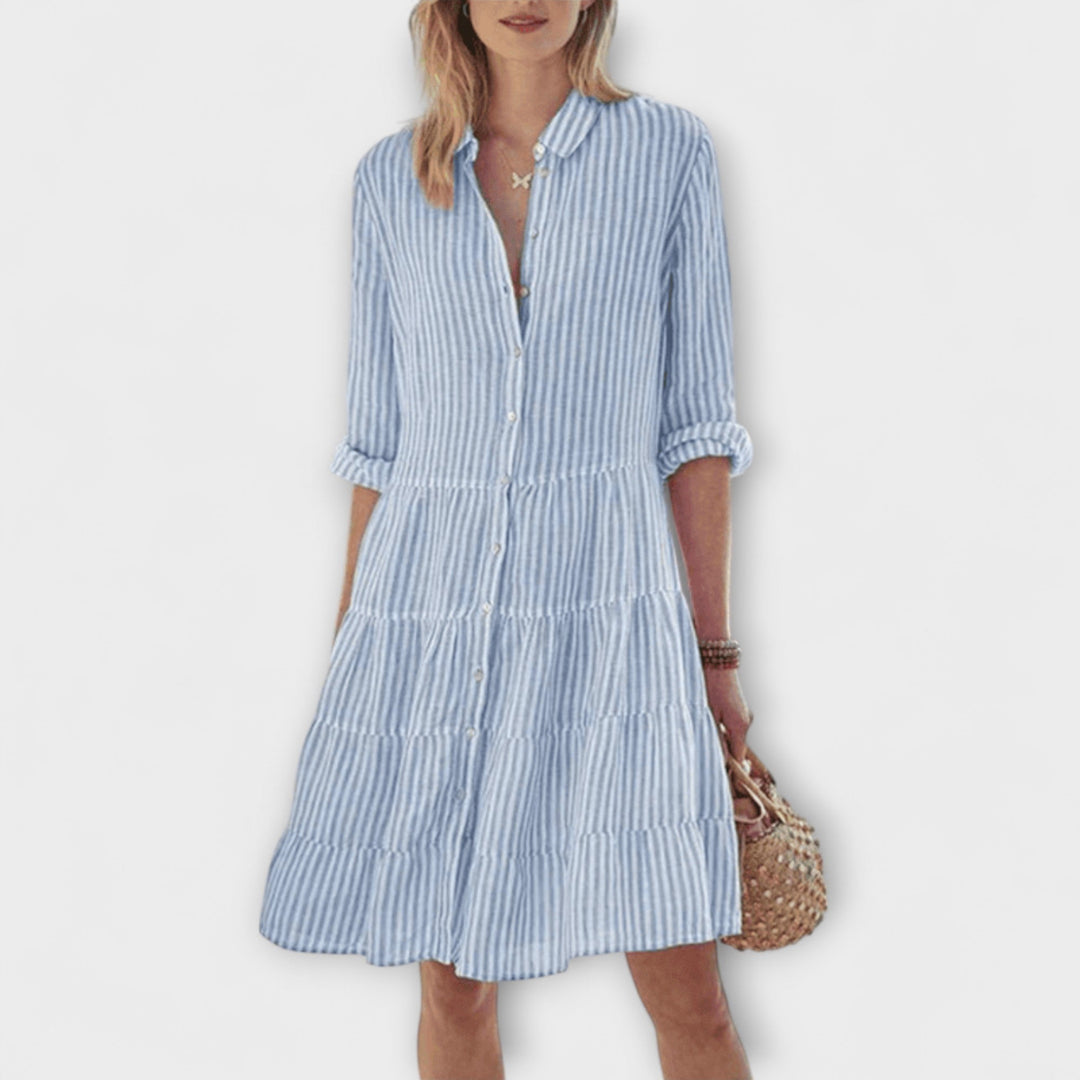 Woman wearing the Renee™ striped button-through shirt dress with roll-up sleeves, walking outdoors in the sunshine.