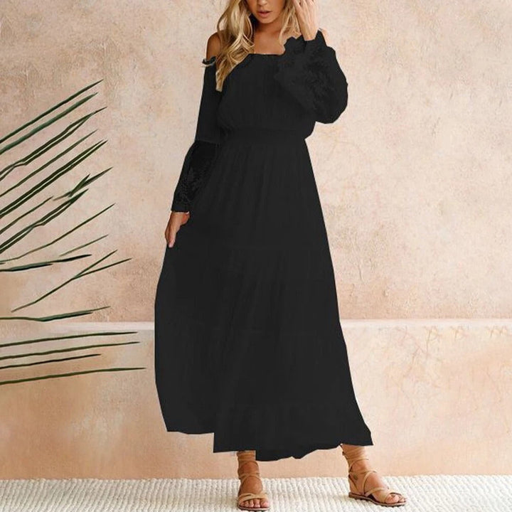 Woman wearing a romantic off-shoulder maxi dress with sheer embroidered sleeves at an evening celebration.