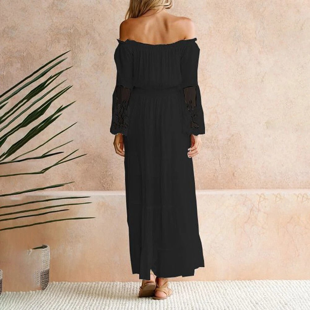 Woman wearing a romantic off-shoulder maxi dress with sheer embroidered sleeves at an evening celebration.