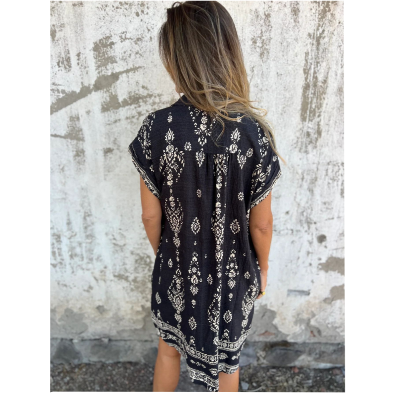 Woman wearing the Isabelle vintage print shirt dress with a button front and soft collar, standing in warm daylight.
