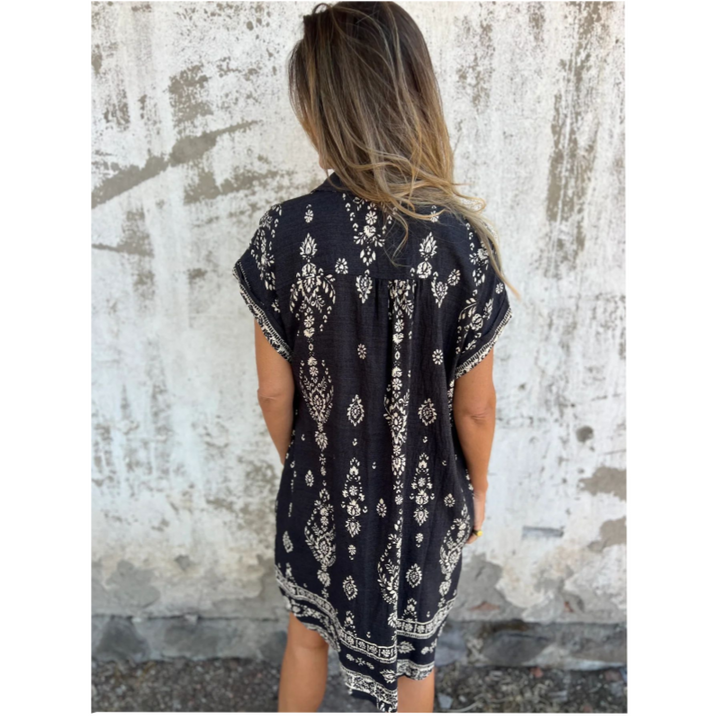 Woman wearing the Isabelle vintage print shirt dress with a button front and soft collar, standing in warm daylight.