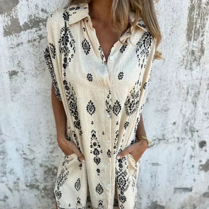 Woman wearing the Isabelle vintage print shirt dress with a button front and soft collar, standing in warm daylight.