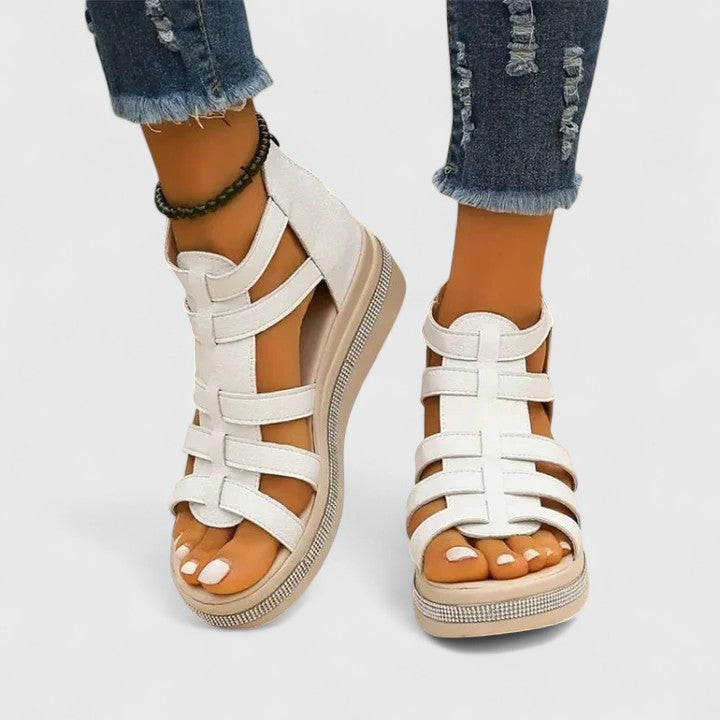 A woman in black strappy sandals walking confidently on a summer day, feet relaxed and supported.