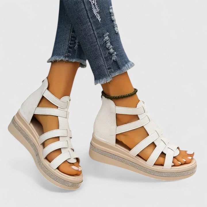 A woman in black strappy sandals walking confidently on a summer day, feet relaxed and supported.