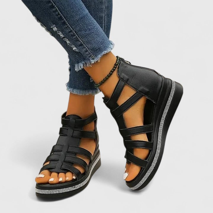 A woman in black strappy sandals walking confidently on a summer day, feet relaxed and supported.