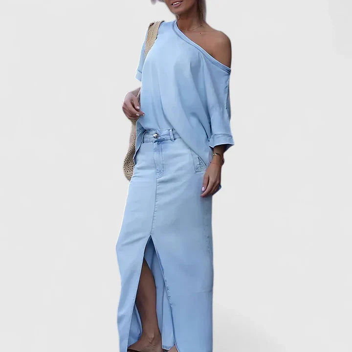 A woman in an asymmetric two-piece skirt set with a front slit, styled for an elegant occasion.