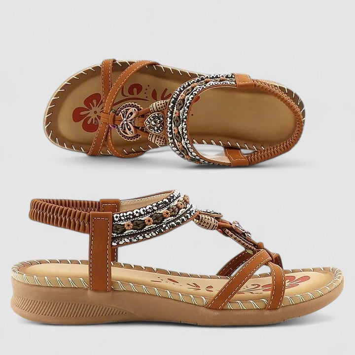 A woman walking comfortably outdoors in cushioned wide-fit orthopaedic sandals with a beaded T-strap and stretch slingback.