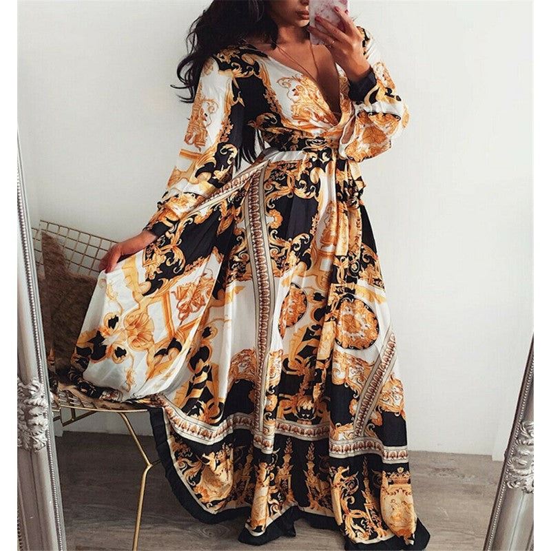 Woman at golden hour wearing the Eileen vintage print maxi dress with a waist belt and long statement sleeves.