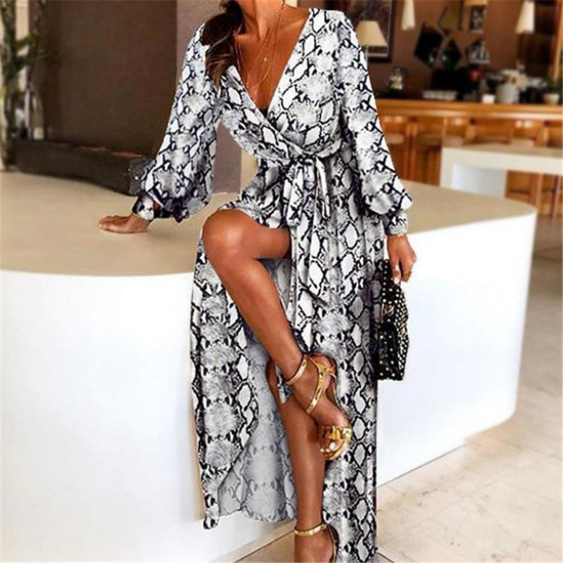 Woman at golden hour wearing the Eileen vintage print maxi dress with a waist belt and long statement sleeves.