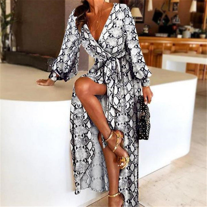 Woman at golden hour wearing the Eileen vintage print maxi dress with a waist belt and long statement sleeves.