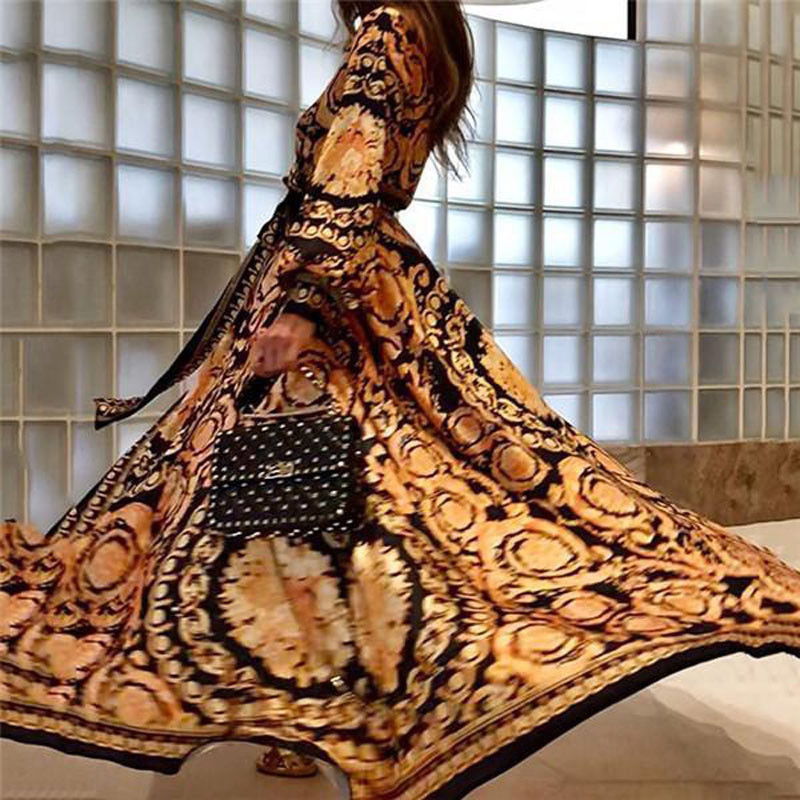 Woman at golden hour wearing the Eileen vintage print maxi dress with a waist belt and long statement sleeves.